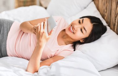 Akıllı Telefonlu Asyalı Kız Mobil Uygulama Kullanıyor Yatakta Yatıyor