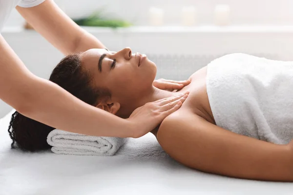 Young black lady getting body massage at spa — Stock Photo, Image
