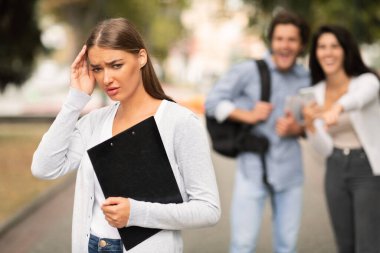 Üniversitenin dışında yürüyen bir grup öğrenci tarafından zorbalığa uğrayan kız