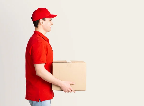 Doručení domů. Kurýr v uniformě doručuje balík ke dveřím. — Stock fotografie