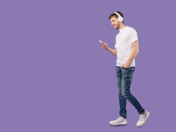 Портрет молодого чоловіка з навушниками за допомогою смартфона — стокове фото