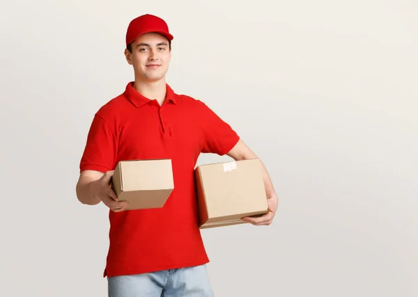 Aspetto il pacco. Uomo di consegna in uniforme dà pacco a casa — Foto Stock