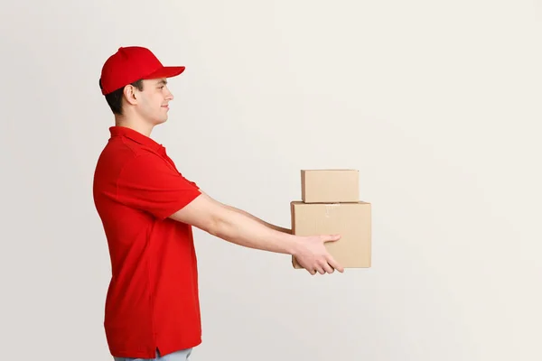 Compras de comercio electrónico entregadas a domicilio. Mensajero sostiene cajas en las manos — Foto de Stock