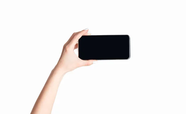 Chica irreconocible sosteniendo teléfono inteligente con pantalla vacía, aislado en blanco. Espacio vacío para texto o diseño en pantalla — Foto de Stock