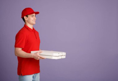 Kurye servisi. Kırmızı üniformalı genç kurye eve pizza getiriyor.