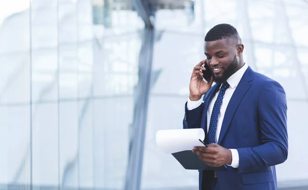 Empresario africano hablando por celular negociando acuerdo de pie al aire libre —  Fotos de Stock