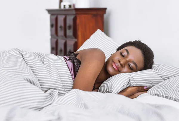 Africana chica americana duerme en la cama en el interior del dormitorio —  Fotos de Stock