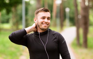 Kulaklıklı ve müzik dinleyen genç bir adam.