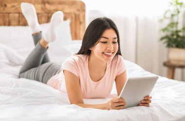 Evdeki Yatakta Dijital Tablet kullanan Koreli Kadın