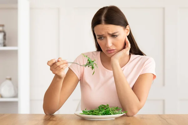 Нещаслива жінка, змучена харчуватися зеленим салатом вдома — стокове фото