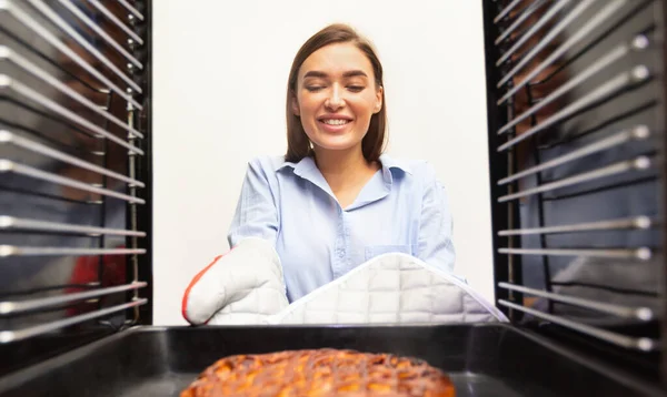 Veselá hospodyňka odstraňuje chutný koláč z trouby — Stock fotografie