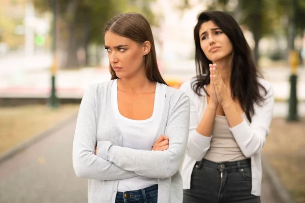 Meisje bedelen beledigd vrouwelijke vriend naar blijven vrienden staan buiten — Stockfoto