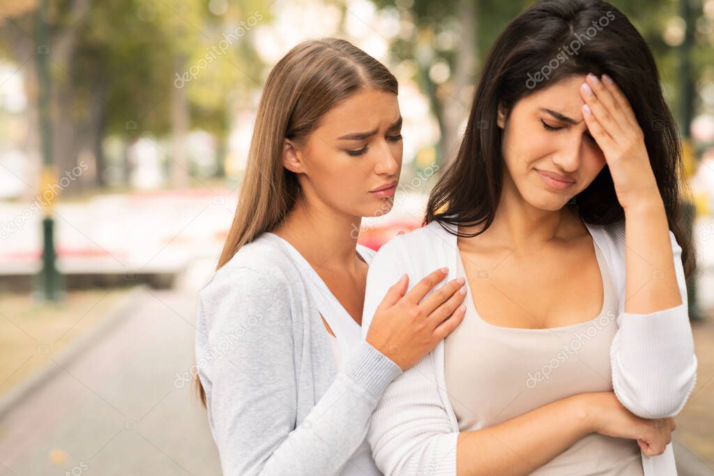 Compassionate Friend Supporting Crying Girl Standing In Park