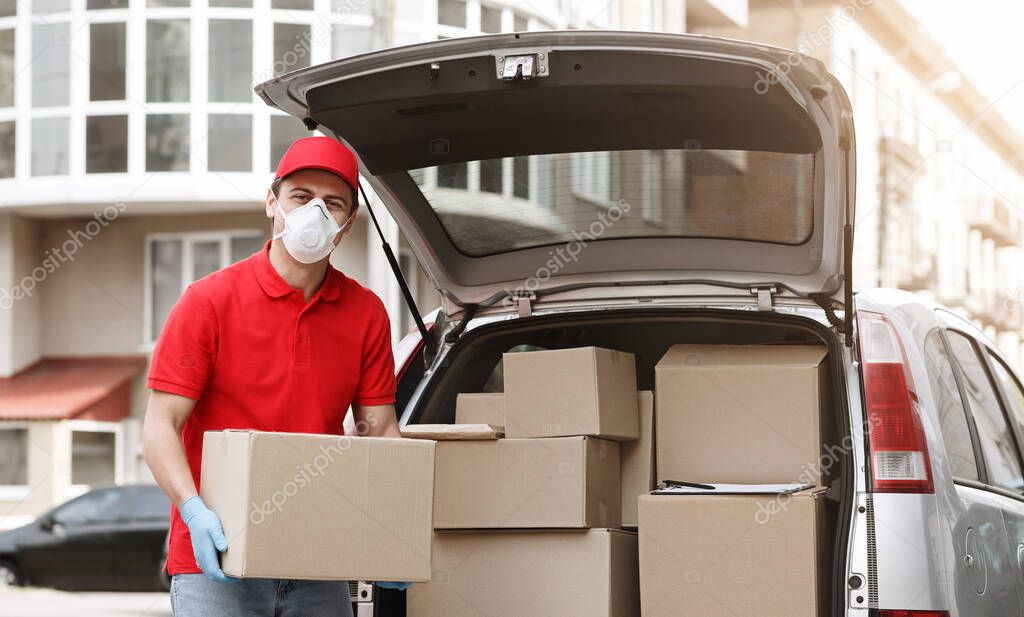 Fast delivery of parcels to house during pandemic concept. Deliveryman takes out boxes of car on street