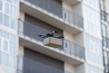 Şehrin üzerinde uçan karton kutulu elektrikli drone.