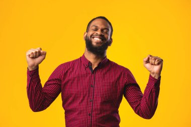 Mutlu siyah adam ellerini kaldırarak zafer kazanıyor.