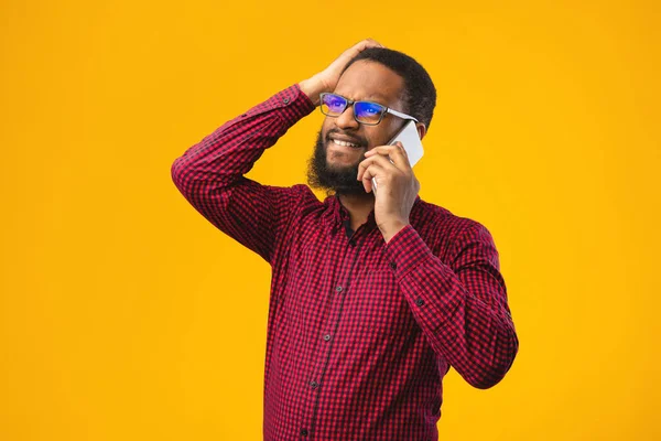 Zestresowany czarny facet rozmawiający przez telefon i gestykulujący — Zdjęcie stockowe