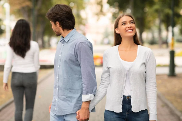 Pojkvännen tittar på annan kvinna gå med flickvännen i parken — Stockfoto