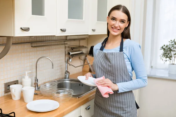 Girl drying the dishes, wiping them off — Stock Photo, Image