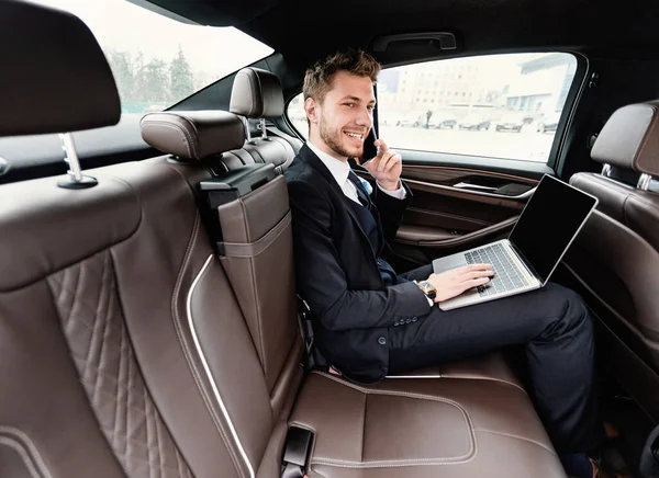年轻的商人在汽车里用智能手机交谈 — 图库照片