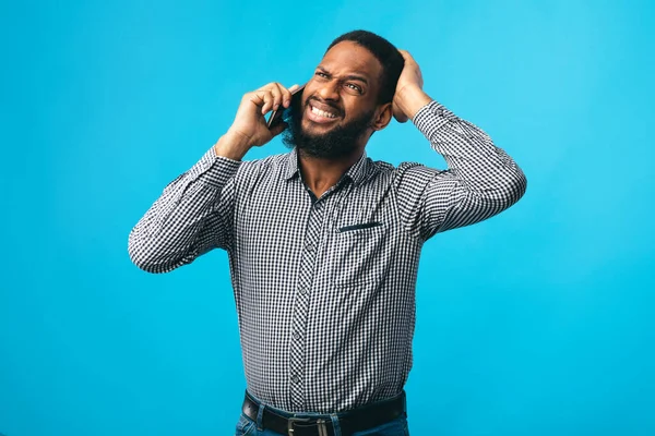 Tipo negro estresado hablando por teléfono y haciendo gestos —  Fotos de Stock