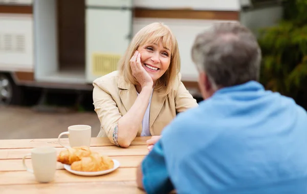 Щаслива зріла жінка з чоловіком снідає разом на кемпінгу — стокове фото