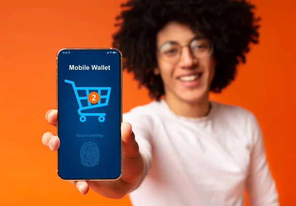 Bushy μαύρος τύπος δείχνει κινητό τηλέφωνο με online φόρμα πληρωμής — Φωτογραφία Αρχείου