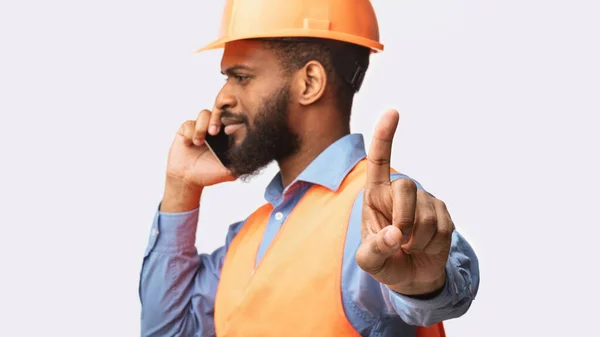 Construtor falando no telefone Gesturing Espere um minuto, fundo branco — Fotografia de Stock