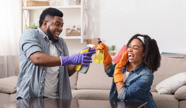 Feliz serviço de limpeza. alegre preto casal ter diversão enquanto fazendo trabalho doméstico juntos — Fotografia de Stock