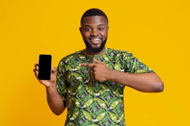 Mutlu Afrikalı adam boş akıllı telefon ekranını işaret ediyor.