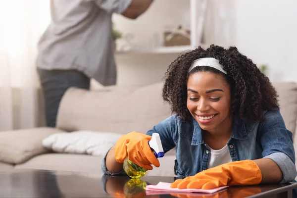 Afrikaans paar maken lente-schoonmaken thuis samen, vrouw afvegen tafel — Stockfoto