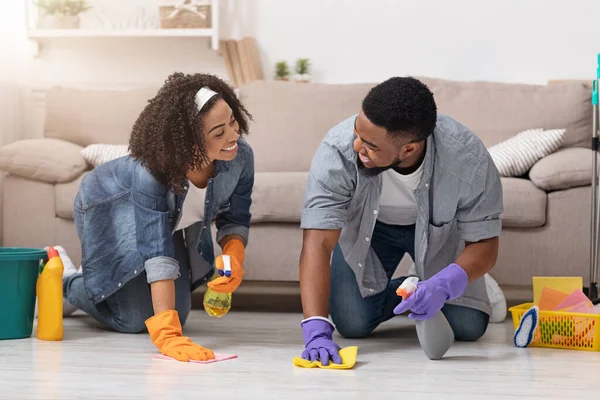 家庭概念。年轻的黑人夫妇一起在他们的公寓里做春季清洁 — 图库照片