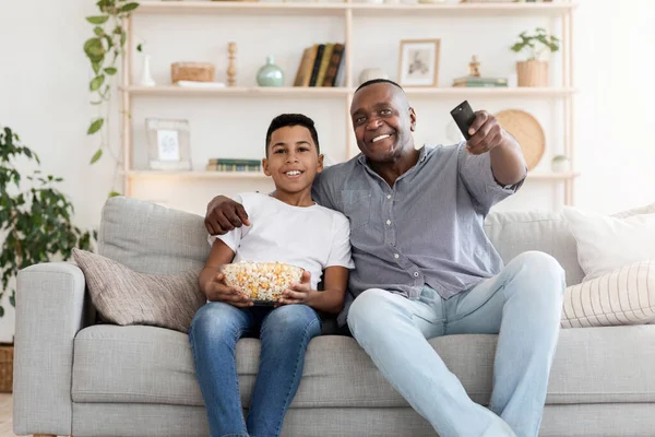 Ευτυχισμένος μαύρος παππούς και ο προ-έφηβος εγγονός του βλέποντας τηλεόραση μαζί στο σπίτι — Φωτογραφία Αρχείου