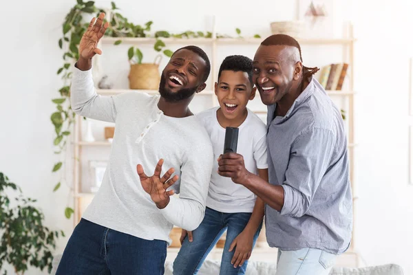 Alegre pai africano, filho e avô se divertindo em casa, cantando juntos — Fotografia de Stock