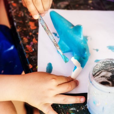 Bir çocuk bir köpekbalığı boyalar