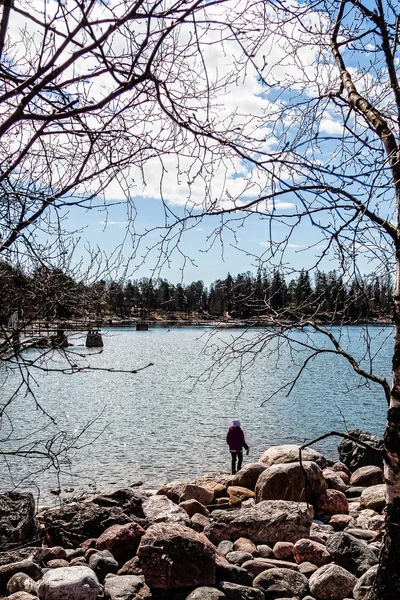 Een meisje loopt langs de oever van het meer — Stockfoto