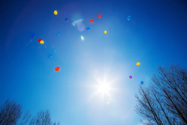 Balões coloridos voam no céu azul — Fotografia de Stock