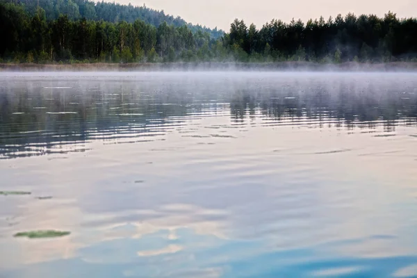 A névoa paira de manhã sobre o lago — Fotografia de Stock