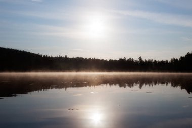 Sis sabah göl üzerinde asılı.