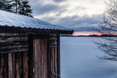 Ahşap ev göl kışın duruyor.