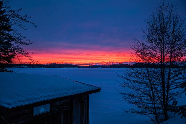 Ahşap ev göl kışın duruyor.