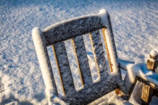Η πίσω πλευρά της ξύλινης καρέκλας είναι κάτω από το χιόνι — Φωτογραφία Αρχείου