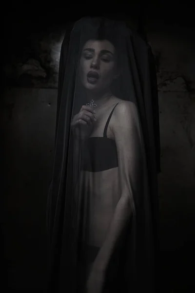 woman veiled by sheer black fabric