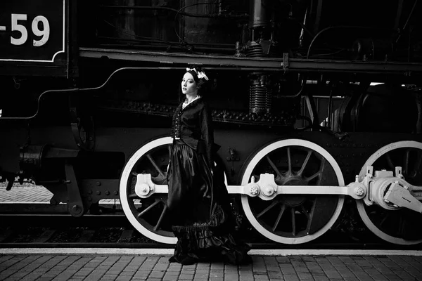 Kobieta w vintage sukienka w pobliżu lokomotywa — Zdjęcie stockowe