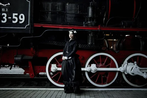 Donna in abito vintage vicino a vapore locomotiva — Foto Stock