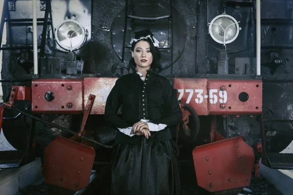 Donna in abito vintage vicino a vapore locomotiva — Foto Stock