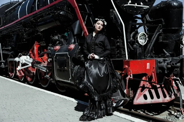 Kobieta w vintage sukienka w pobliżu lokomotywa — Zdjęcie stockowe