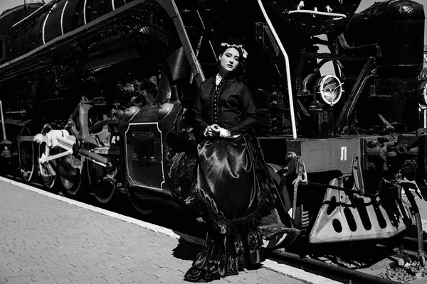 Mujer en vestido vintage cerca de locomotora de vapor — Foto de Stock