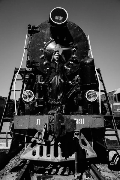 Žena v vintage šaty poblíž parní lokomotiva — Stock fotografie