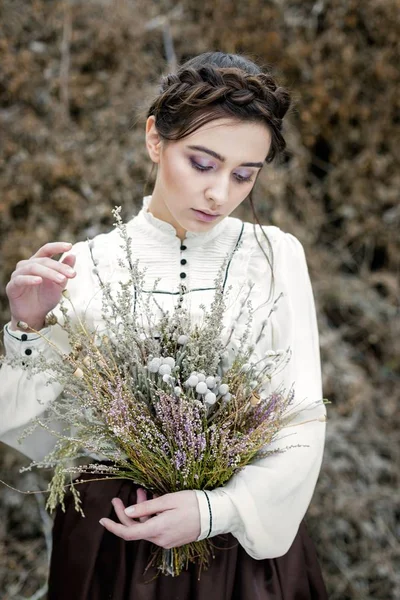 Mulher segurando buquê de flores silvestres — Fotografia de Stock